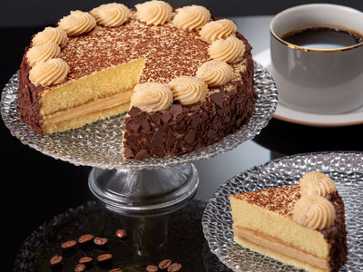 Two layers of coffee washed cake are filled with the traditional custard and topped with a light and delectable coffee whipped cream. As an extra touch, this delight is then sprinkled with dark chocolate and cocoa and adorned with a chocolate occasion plaque.